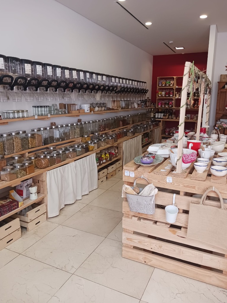 Interior da Loja Granel da Vila com dezenas de frascos a granel e decoração em madeira